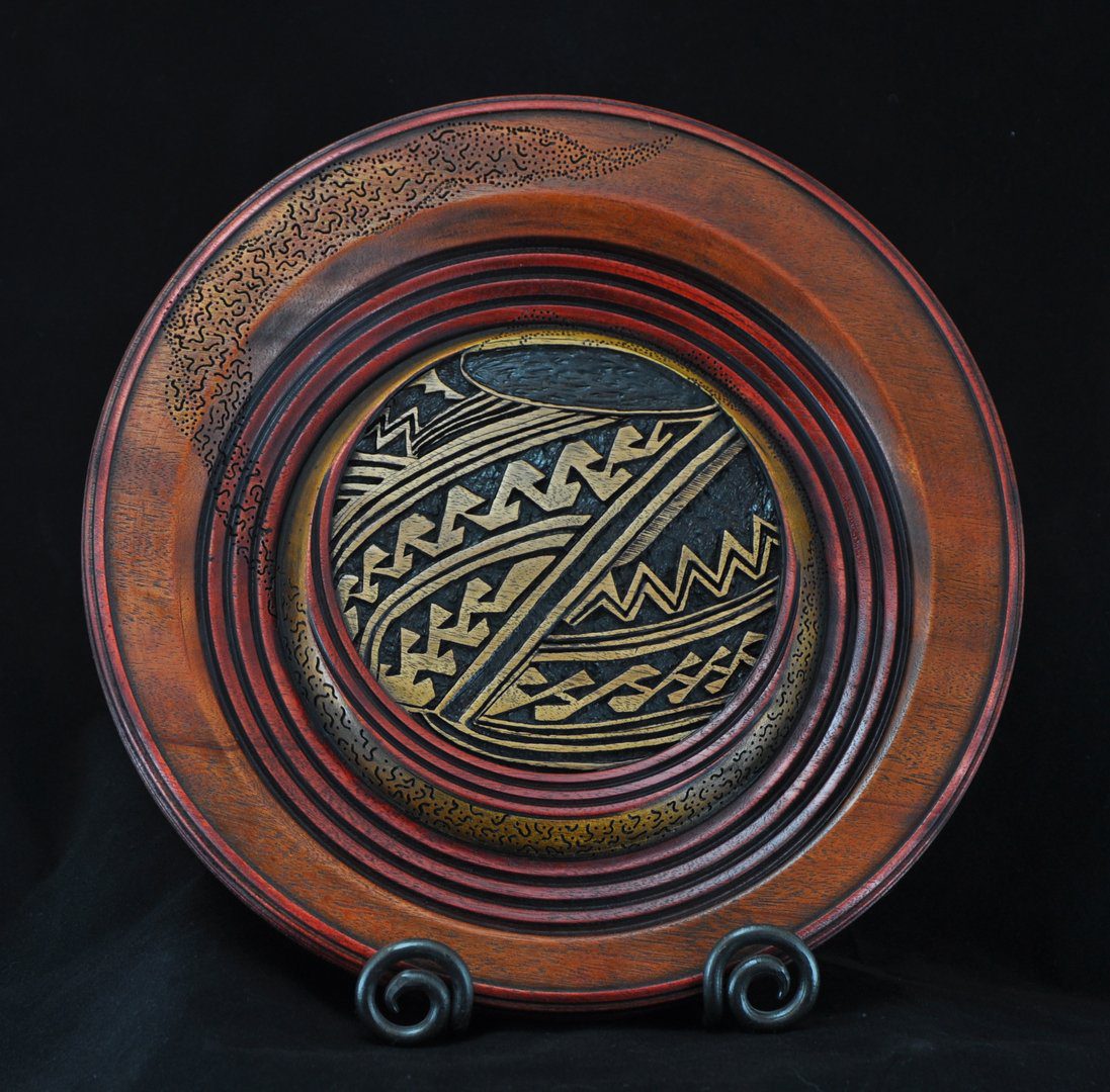A plate with a design on it sitting on top of a stand.