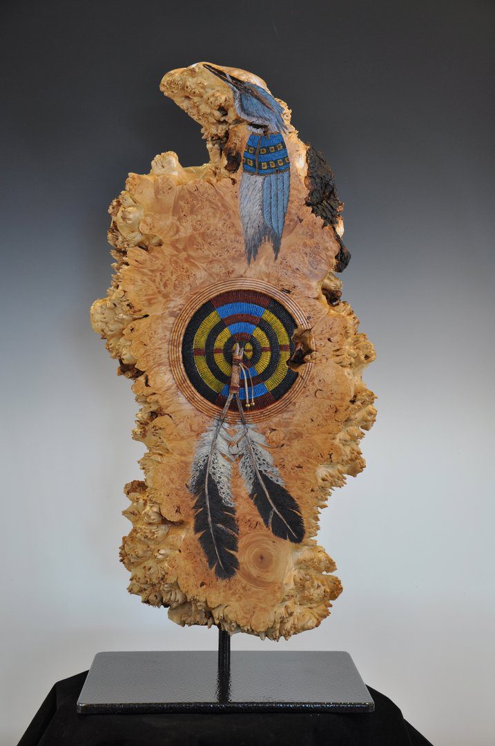 A wooden piece of wood with a feather and a circle on it.