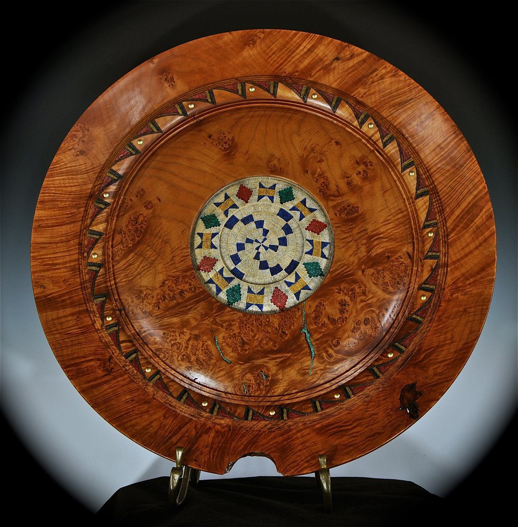 A wooden plate with a mosaic design on it.