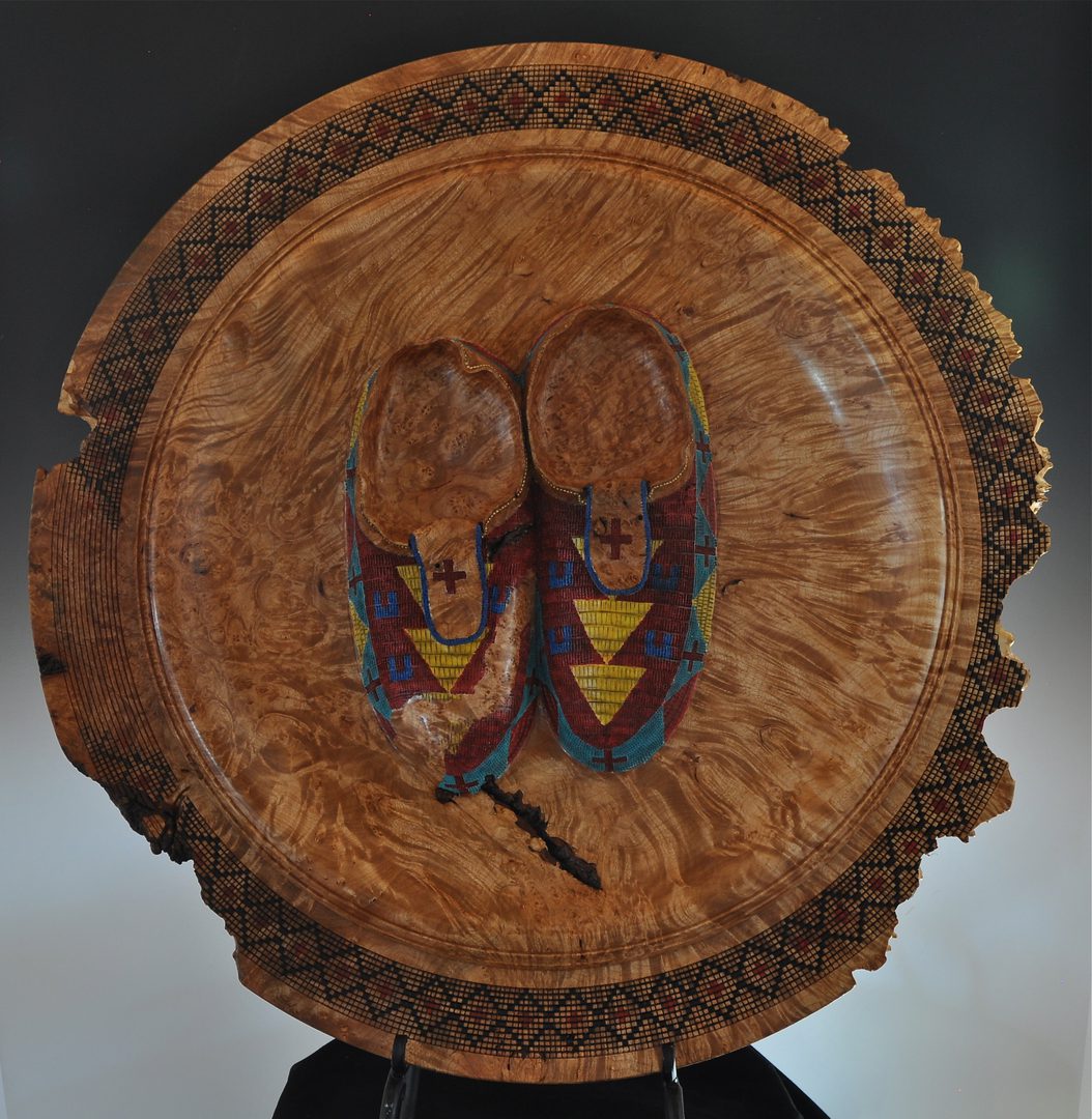 A wooden plate with shoes on it