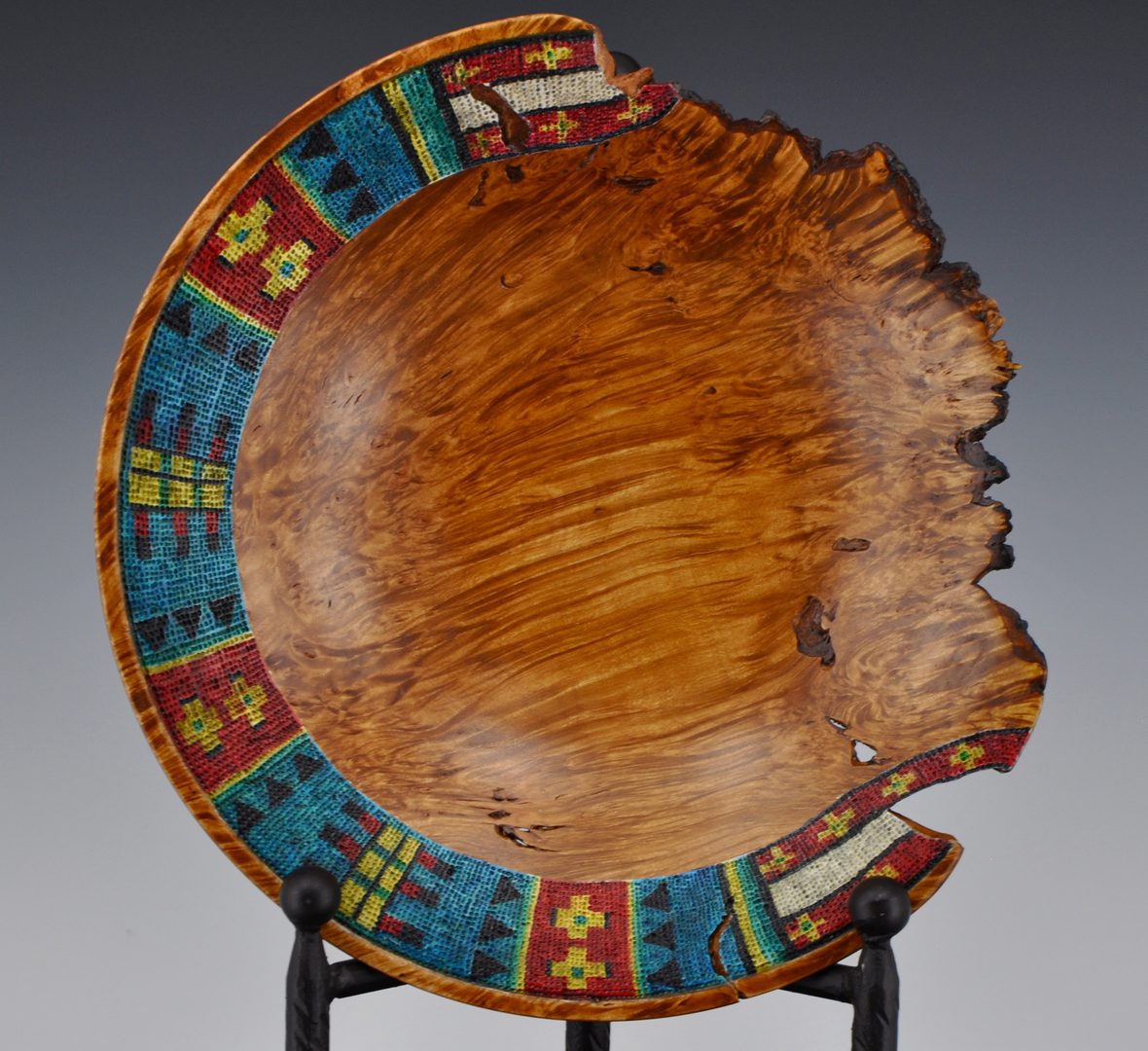 A wooden bowl with colorful designs on it.