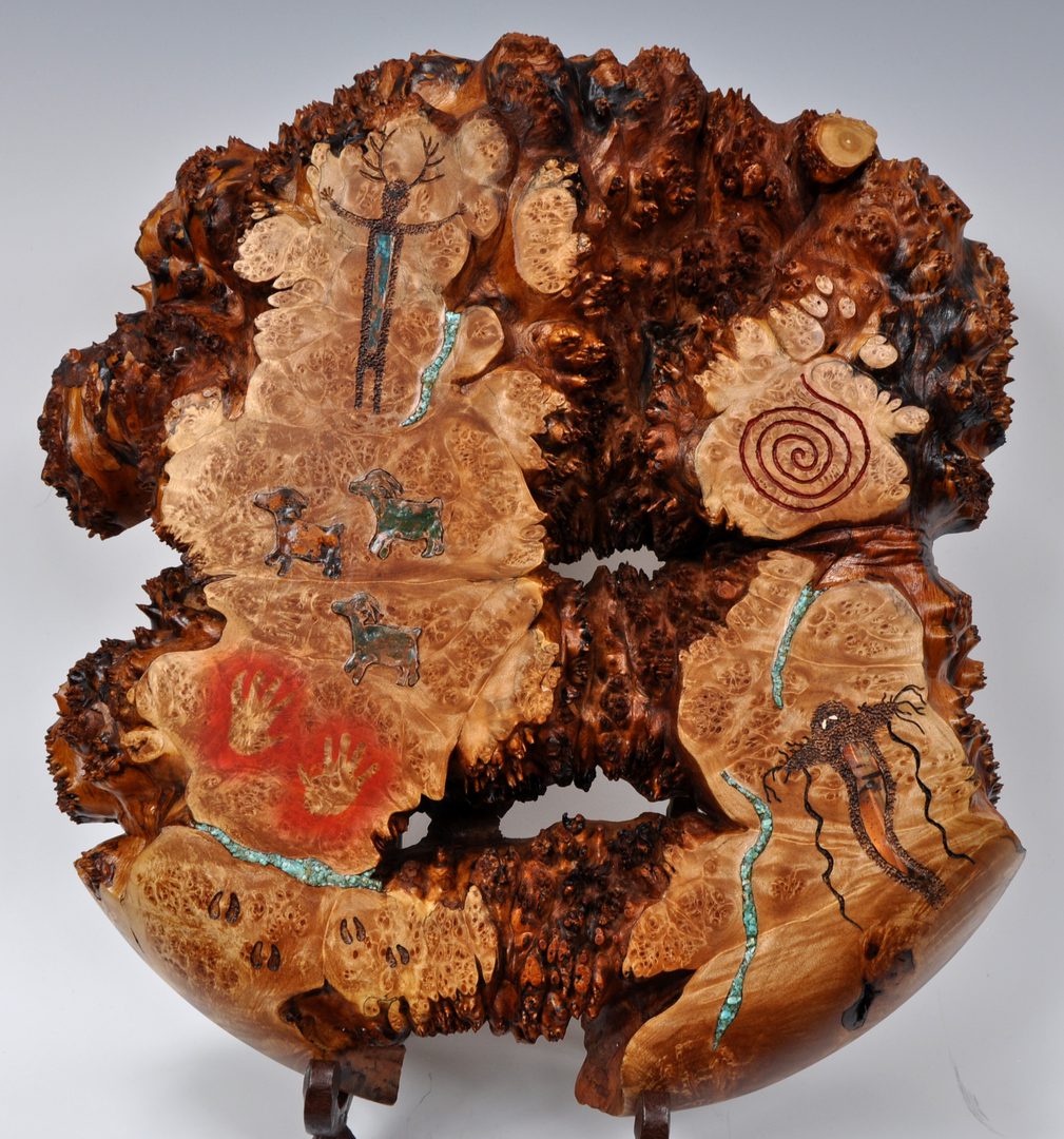 A wooden sculpture with different colored wood and designs.